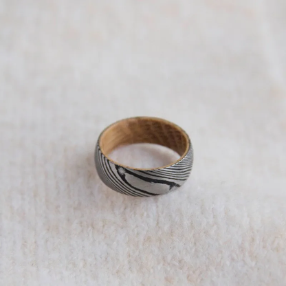 Black and silver patterned ring with a wooden interior.