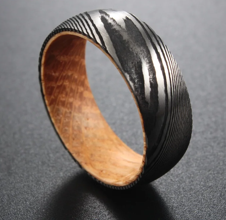 Damascus steel 8mm wedding band with a textured black exterior and wooden interior by Forge and Lumber.