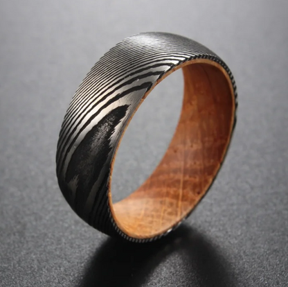 Damascus steel 8mm wedding band with a wood interior by Forge and Lumber, featuring a unique, textured design.