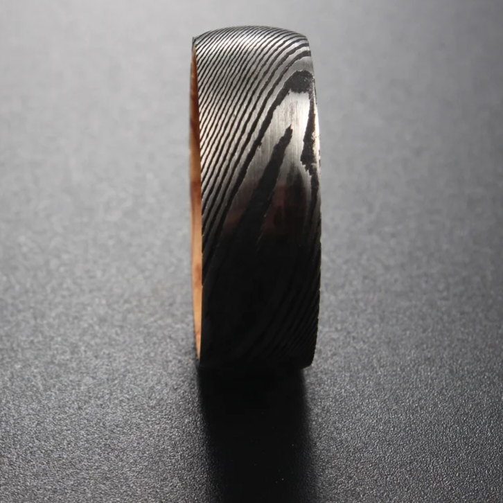Damascus steel 8mm wedding band with a unique wood grain pattern by Forge and Lumber.