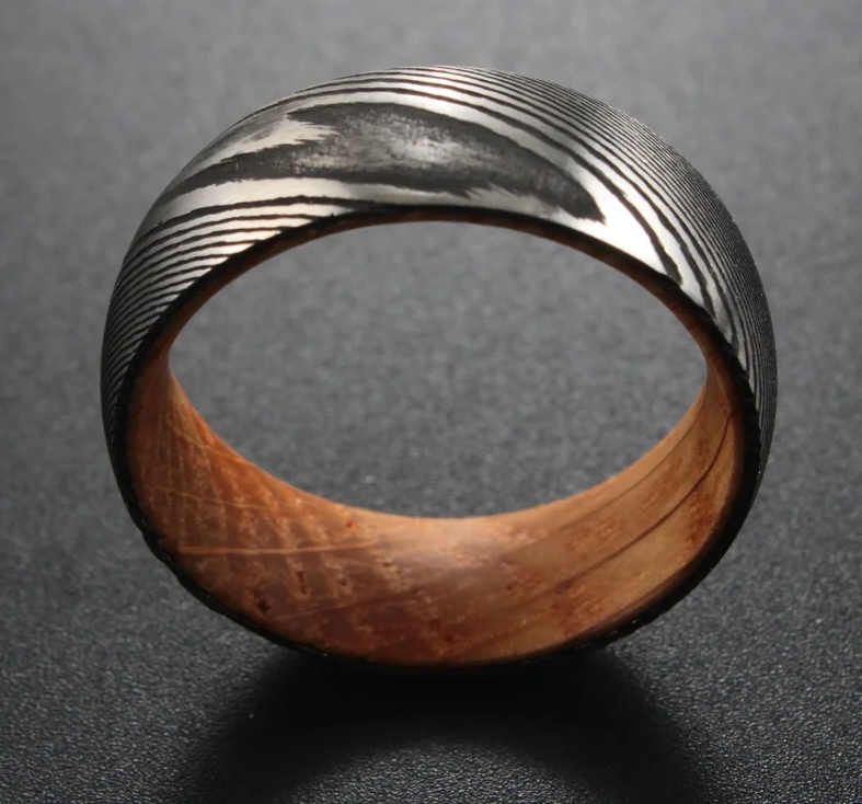 Black and silver patterned ring with a wooden interior.