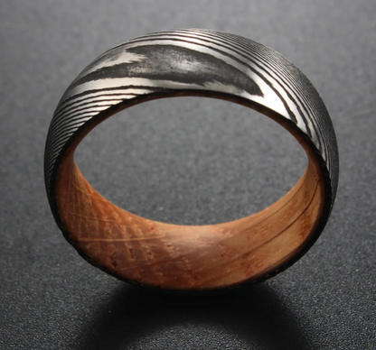 Black and silver patterned ring with a wooden interior.