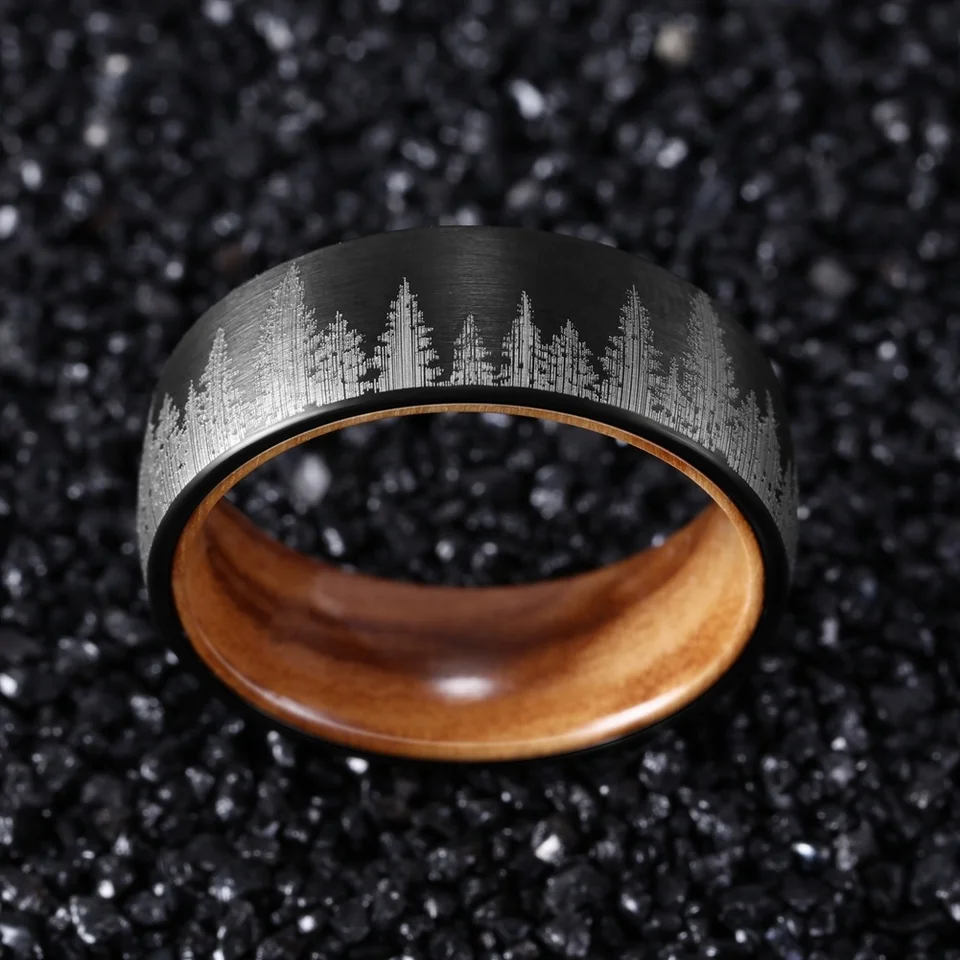 Black durable ring with engraved forest design and wooden interior by Forge and Lumber.