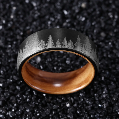 Black durable ring with engraved forest design and wooden interior by Forge and Lumber.