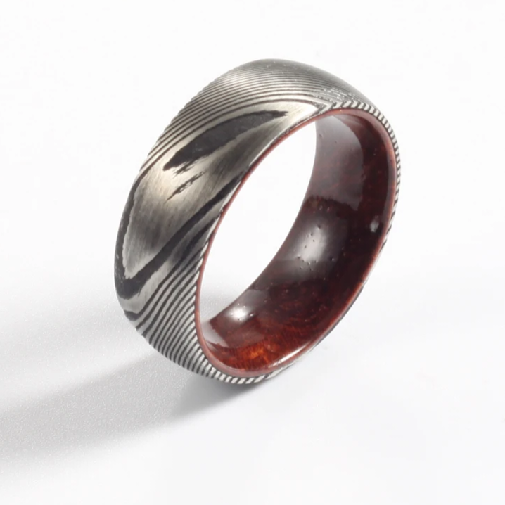 Damascus steel commitment ring with a polished wood interior by Forge and Lumber, available in sizes UK M, N, O.