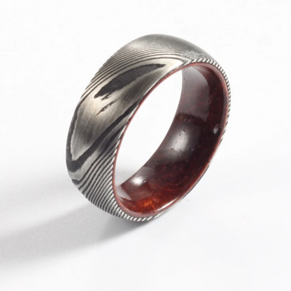 Damascus steel commitment ring with a polished wood interior by Forge and Lumber, available in sizes UK M, N, O.