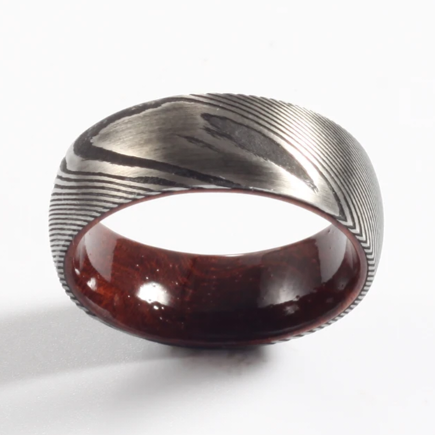 Damascus steel commitment ring with a polished finish and wooden interior by Forge and Lumber.