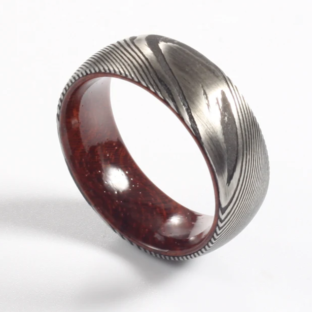 Damascus steel commitment ring with wood inlay, artisan design by Forge and Lumber, available in multiple sizes.