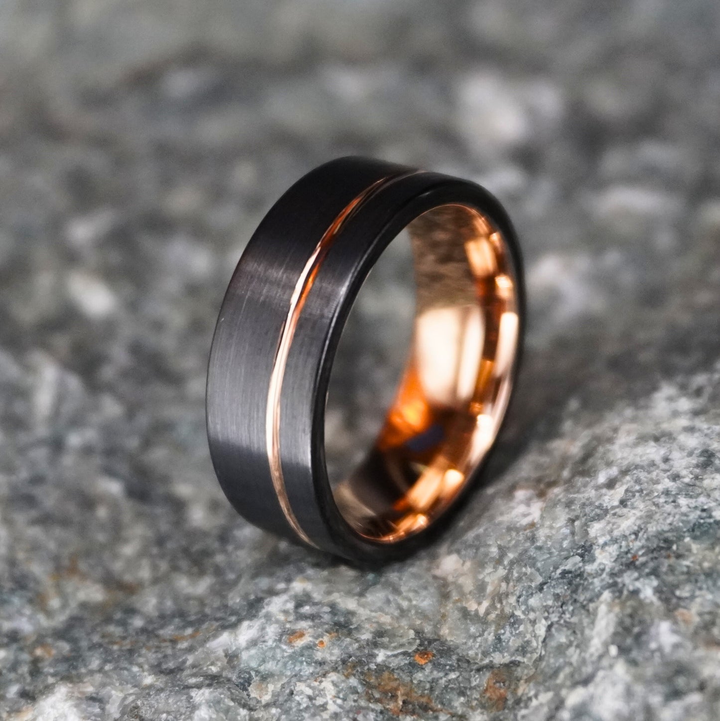 Black and rose gold 8mm wedding band from Forge and Lumber, featuring a brushed finish and blacksmith-inspired design.