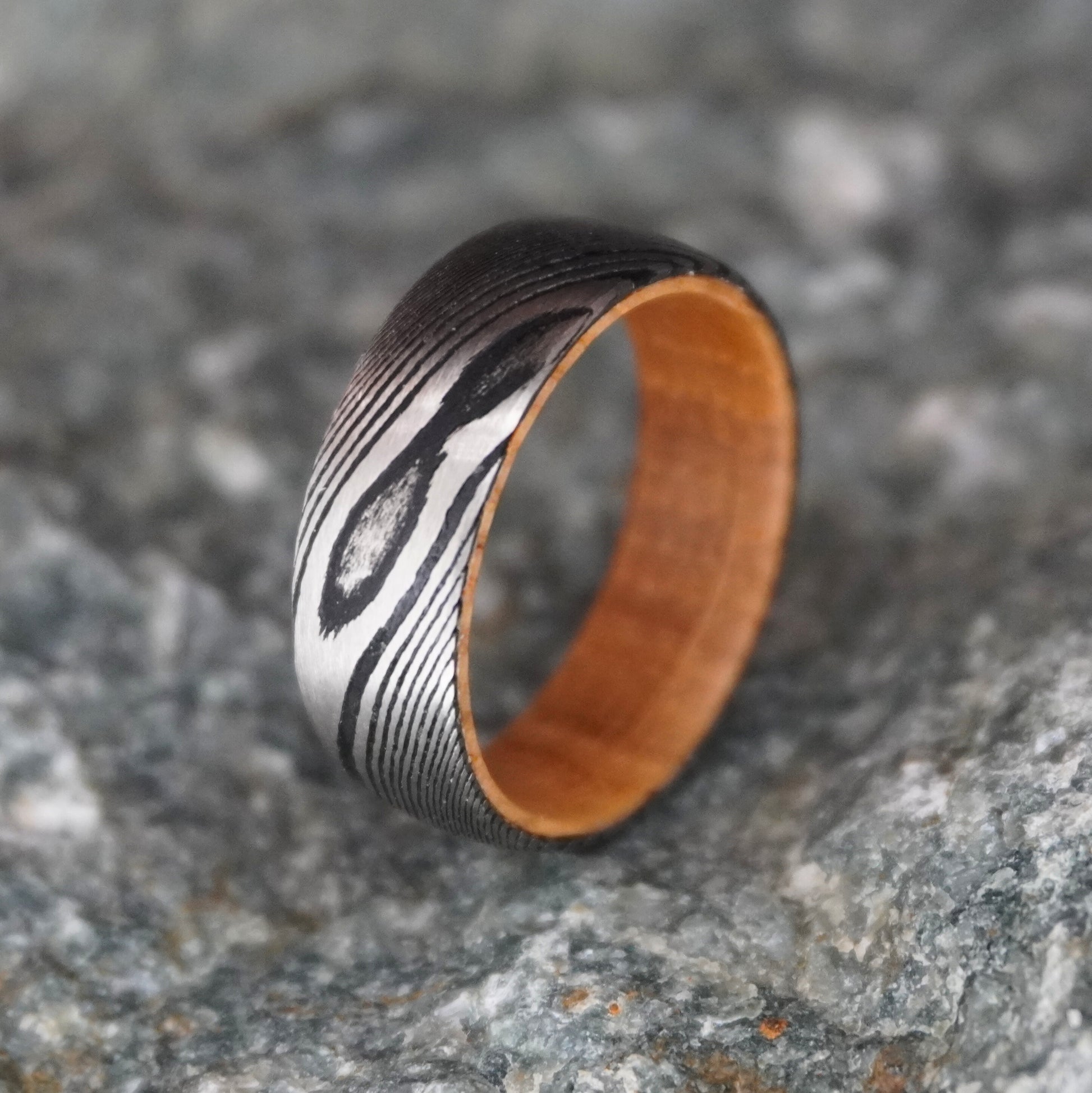 Damascus steel wedding band with wood interior, 8mm width, by Forge and Lumber. Available in sizes UK M, N, O.
