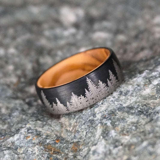 Black durable ring featuring engraved forest design, by Forge and Lumber, ideal for adventurers.