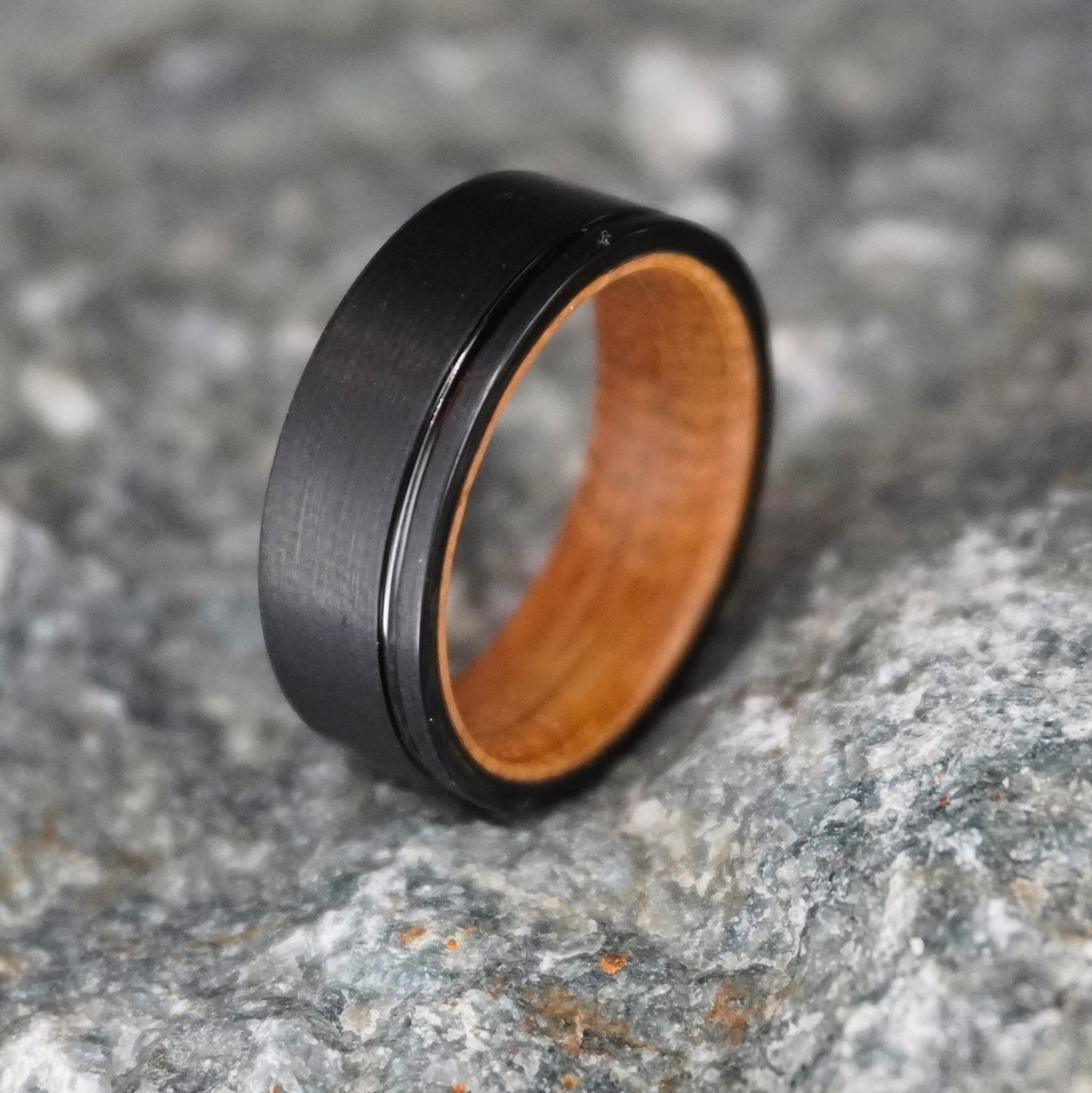 Black brushed barrel ring with 8mm width and wooden interior by Forge and Lumber. Available in sizes UK M to O.