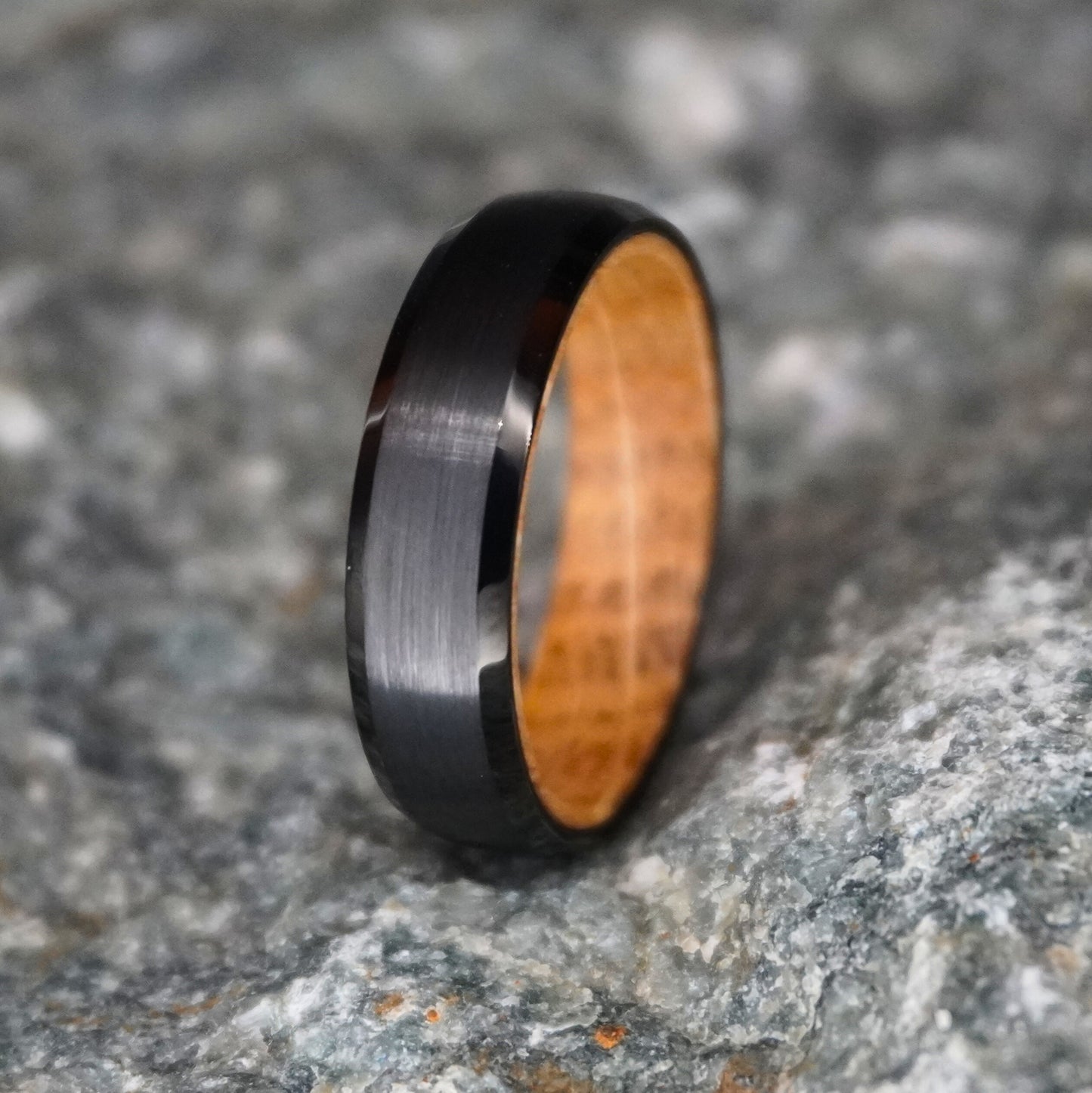 Black 6mm beveled ring with barrel-wood interior by Forge and Lumber.
