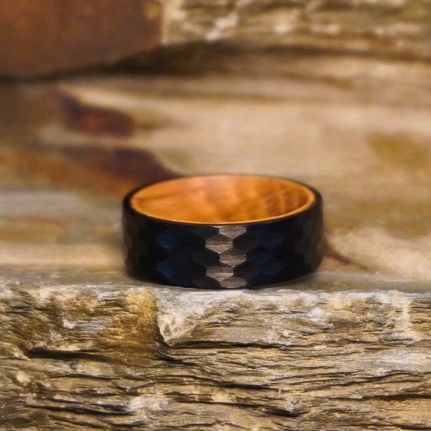 Black 8mm flat ring with a textured surface and wooden interior by Forge and Lumber.