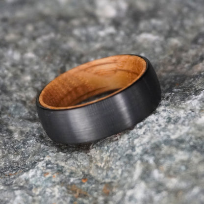 Black barrel wedding band with a wooden interior by Forge and Lumber, available in sizes UK M, N, O.