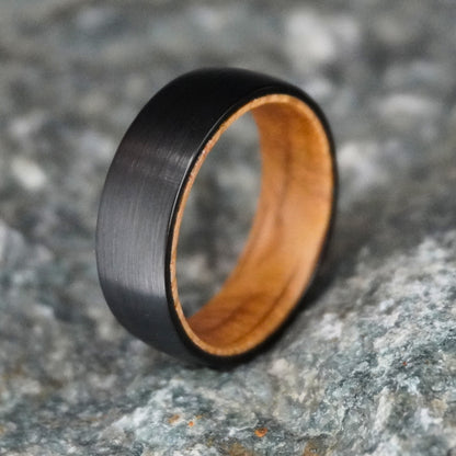 Black barrel wedding band with a brushed finish and wooden interior by Forge and Lumber. Available in sizes UK M to O.