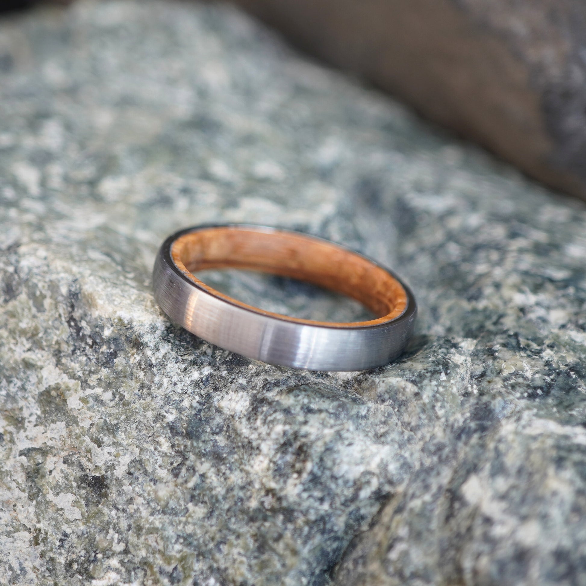 Brushed stainless steel 4mm wedding band with a wooden inner lining by Forge and Lumber.