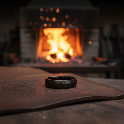 6mm black tungsten ring with a faceted design, The Blacksmith by Forge and Lumber, set against a forge backdrop.