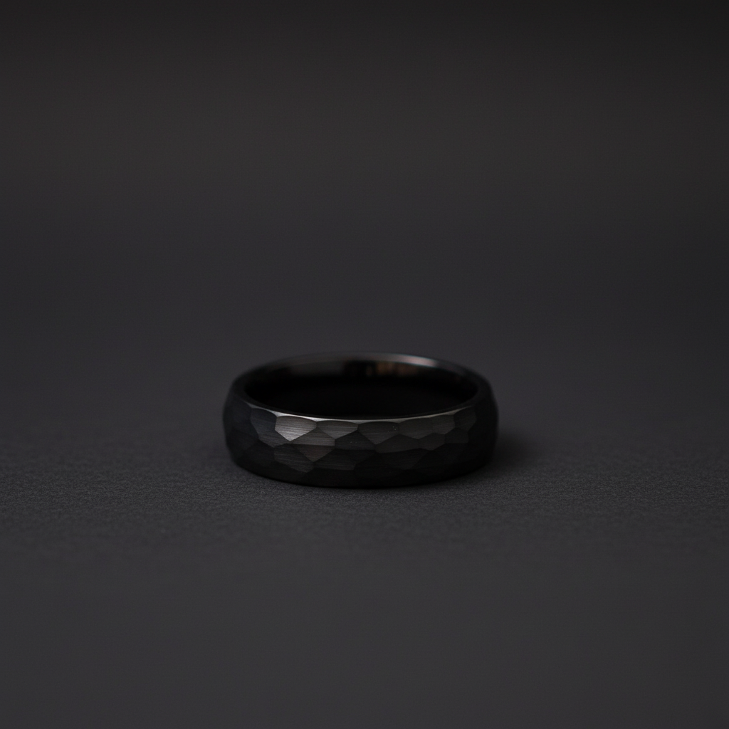 Sleek black ring with a faceted texture, showcasing modern craftsmanship and elegance.