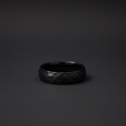 Sleek black ring with a faceted texture, showcasing modern craftsmanship and elegance.