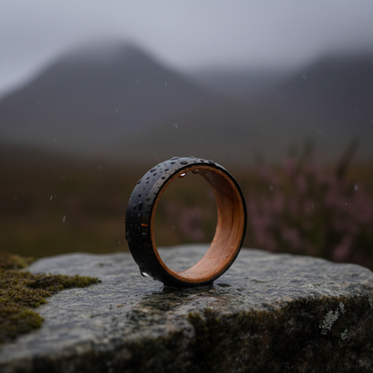 Sleek black and wood bracelet with textured surface, set against a misty landscape. The Speyside - 8mm.