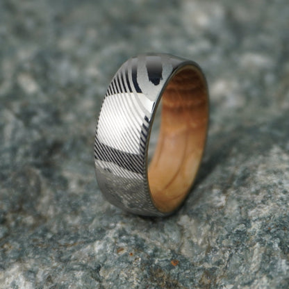 Artisan Damascus ring with 8mm width and wooden interior by Forge and Lumber, available in multiple sizes.